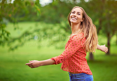 Buy stock photo Shot of a carefree young woman enjoying the outdoors