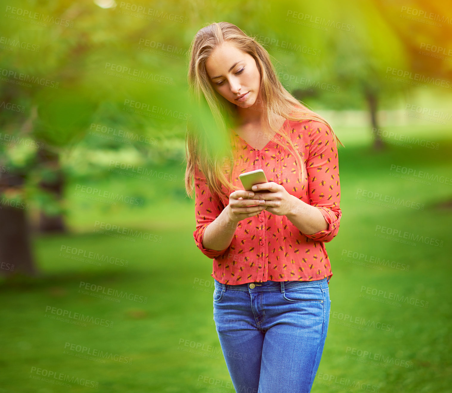 Buy stock photo Shot of a young woman texting on her cellphone outside