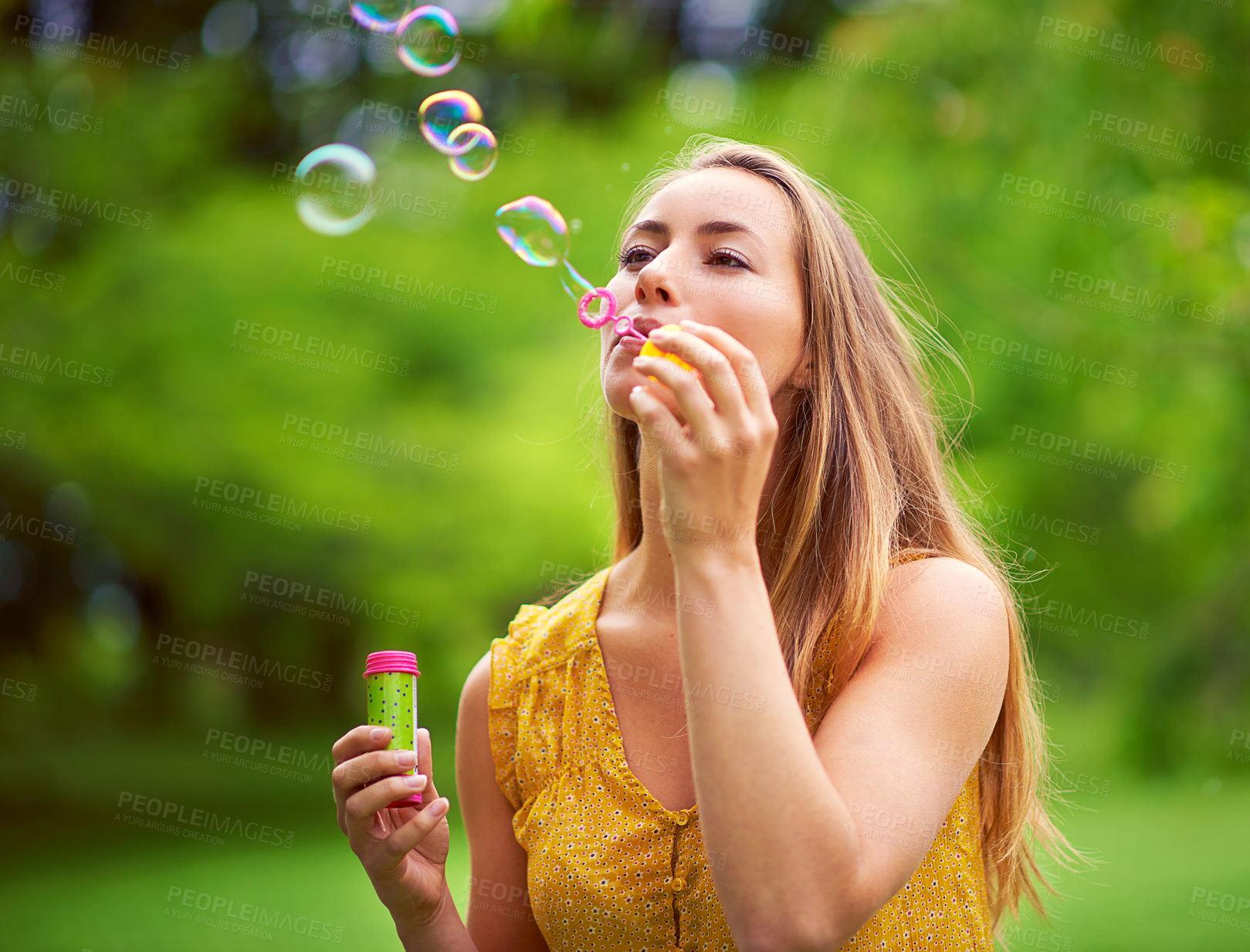 Buy stock photo Nature, playing and woman blowing bubbles in outdoor park for happiness, holiday or summer vacation. Relax, game and female person with soap toy for excitement, joyful or fun weekend in garden