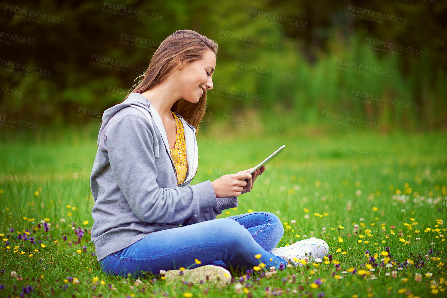 Buy stock photo Woman, tablet and reading on grass with texting, happy or flowers with notification, chat and contact in spring. Girl, student and smile with app on lawn at campus to relax, click and social media