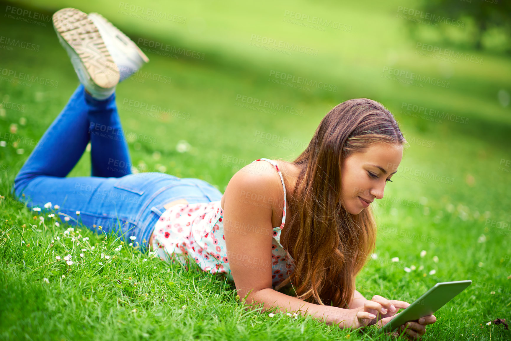 Buy stock photo Relax, happy and woman in grass on tablet for online learning, internet and university website. College, education and person on digital tech for social media, research and working outdoors in park