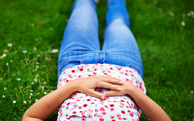 Buy stock photo Cropped shot of a woman relaxing on a patch of grass
