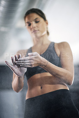 Buy stock photo Shot of a young woman coating her hands with sports chalk