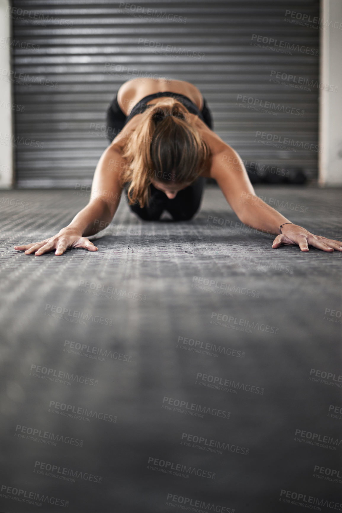 Buy stock photo Shot of a young woman doing stretching exercises at the gym