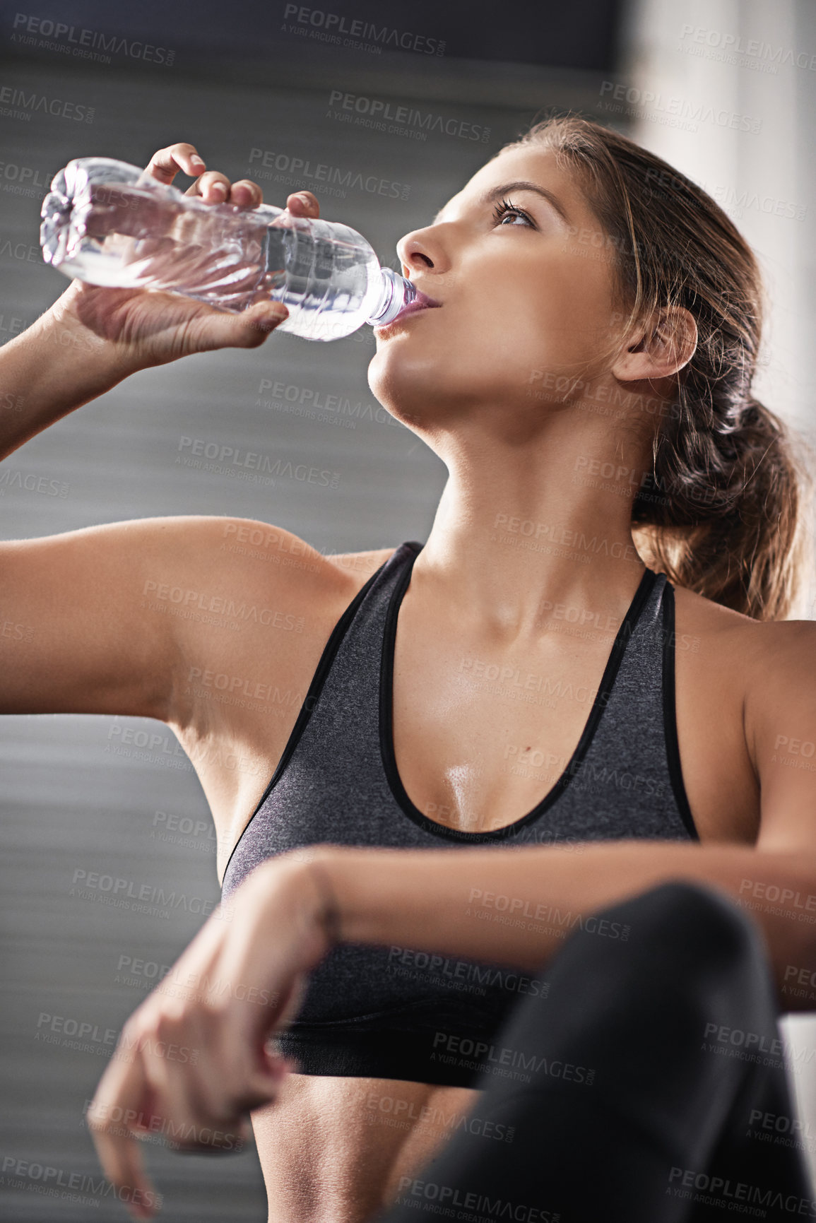 Buy stock photo Gym, woman and drinking water on floor for hydration from training for health or cardio with thirst. Muscle recovery, exercise and athlete for performance or appetite control for wellness in Germany.