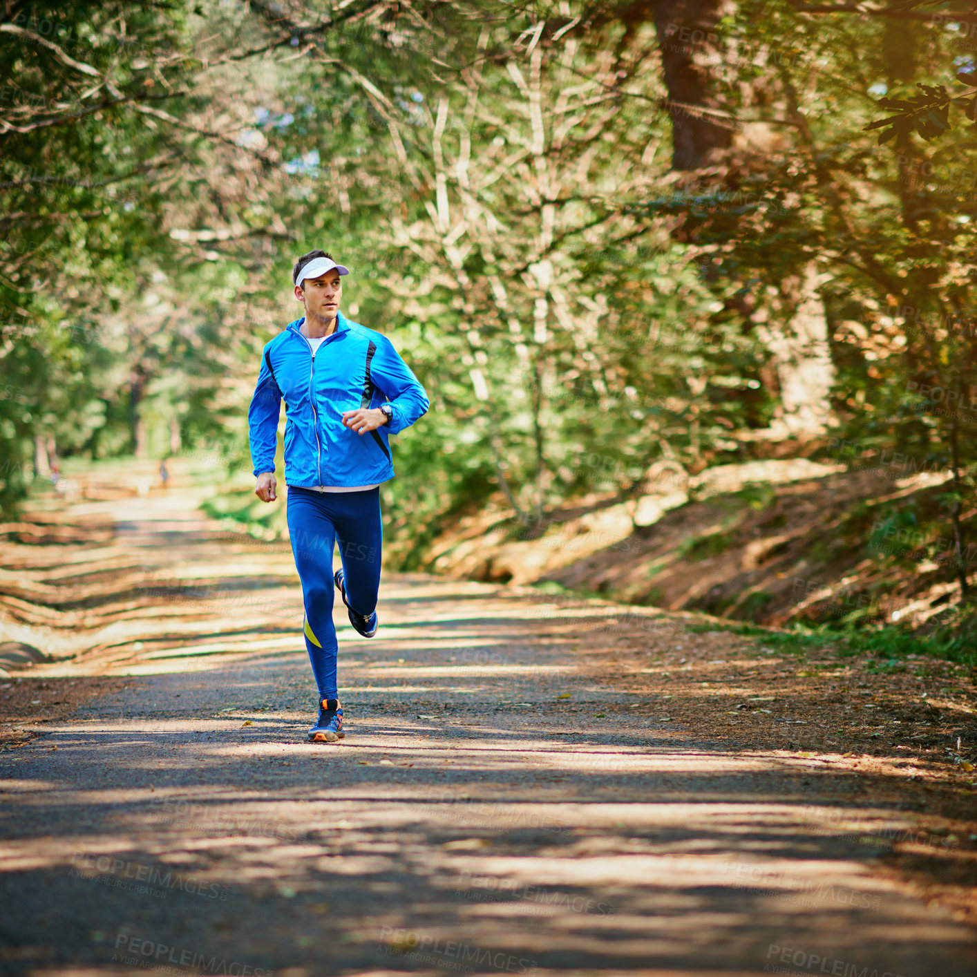 Buy stock photo Shot of a young man running along a trail