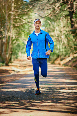 Buy stock photo Shot of a young man running along a trail