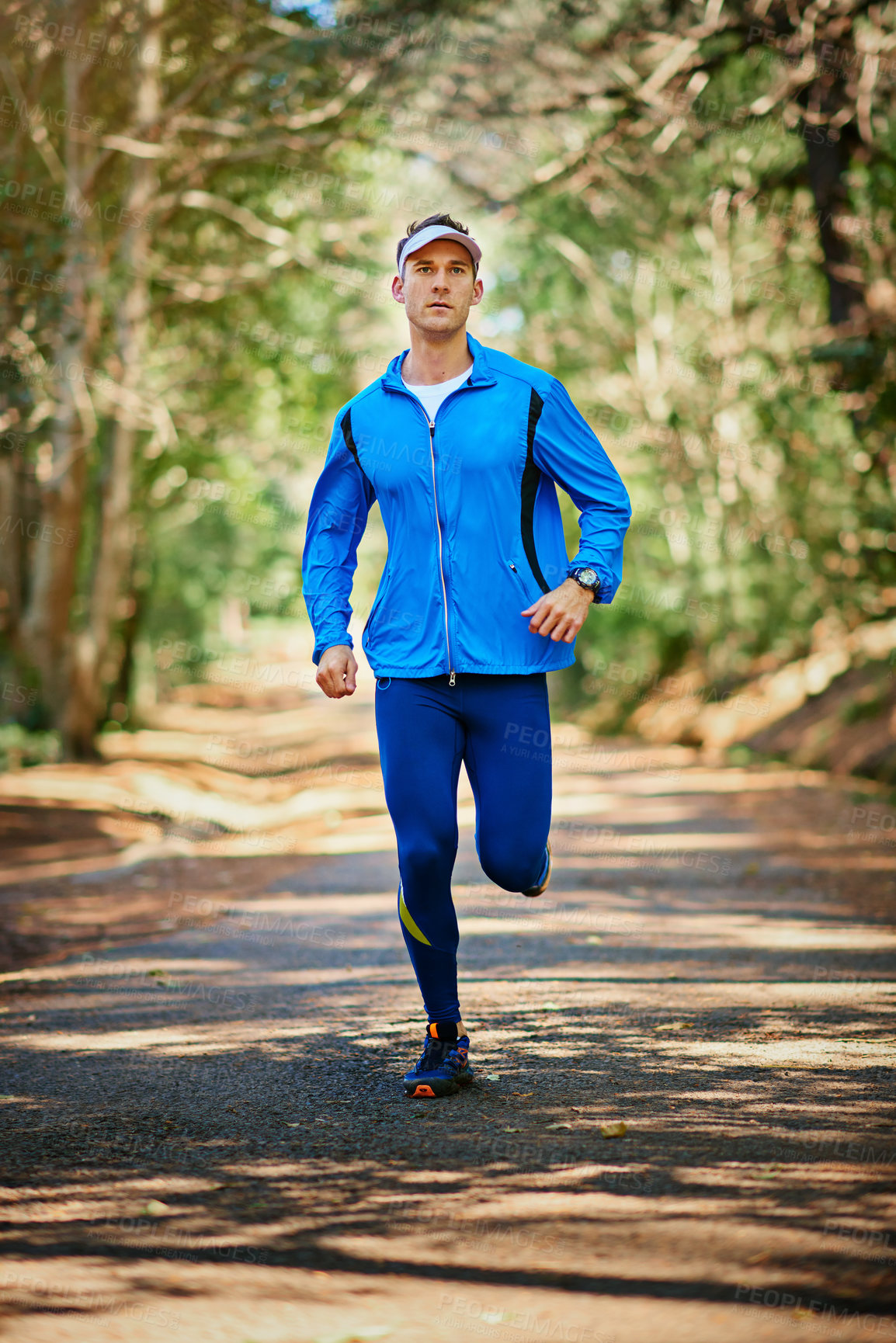Buy stock photo Shot of a young man running along a trail