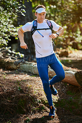 Buy stock photo Shot of a young man running along a nature trail