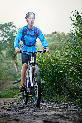 Buy stock photo Shot of a male cyclist riding along a mountain bike trail