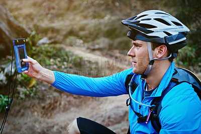 Buy stock photo Shot of a cyclist using the GPS on his smartphone while out for a ride