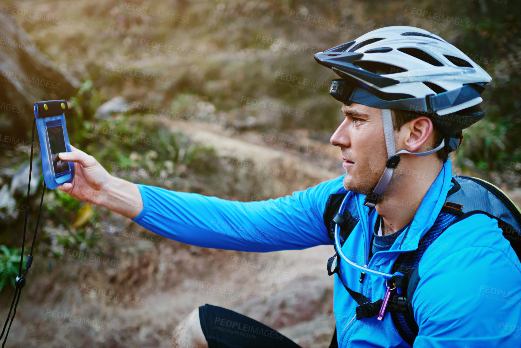 Buy stock photo Shot of a cyclist using the GPS on his smartphone while out for a ride