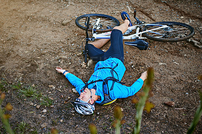 Buy stock photo Shot of a male cyclist who's taken a fall on his mountain bike