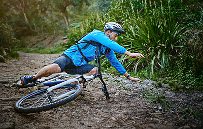 Buy stock photo Shot of a male cyclist who's taken a fall on his mountain bike