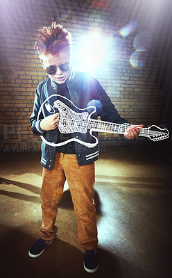 Buy stock photo Shot of a boy playing music on an imaginary guitar