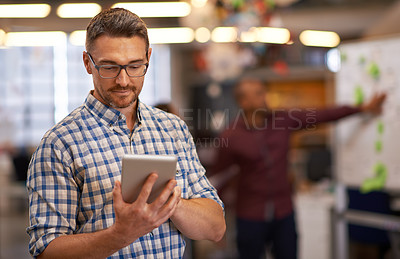 Buy stock photo Cropped shot of a mature businessman using a digital tablet in the office