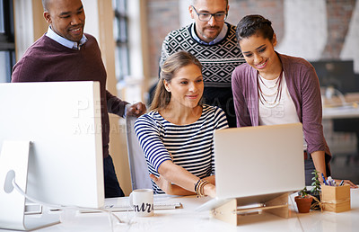 Buy stock photo Shot of a group of designers working together at a computer