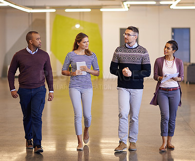 Buy stock photo Shot of a group of coworkers walking alongside each other