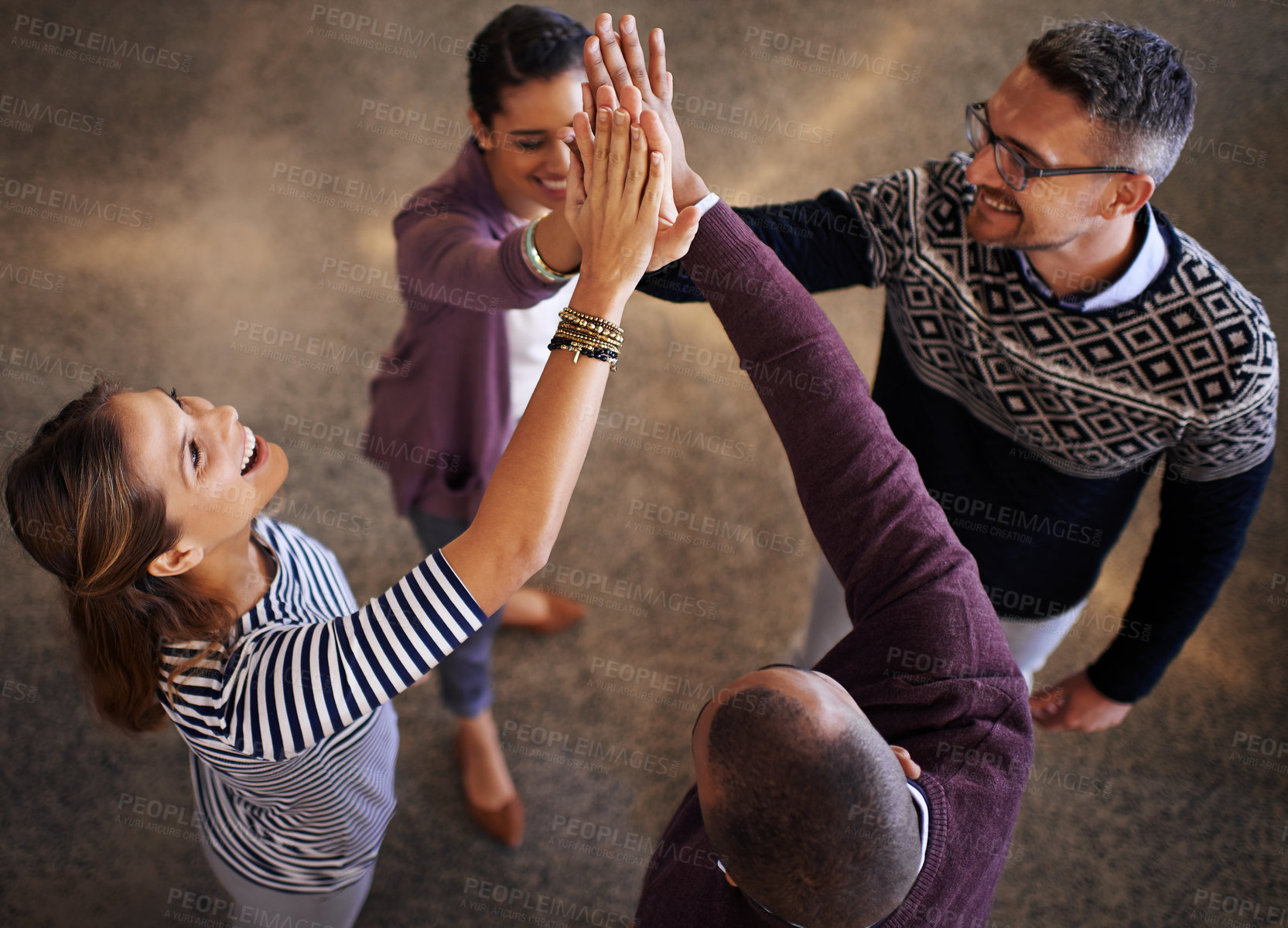 Buy stock photo High angle shot of a group of coworkers giving each other a high five