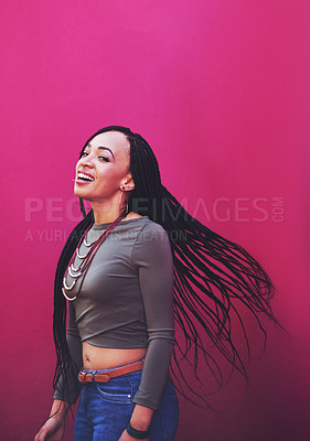 Buy stock photo Shot of an attractive young woman with braids posing against a pink background