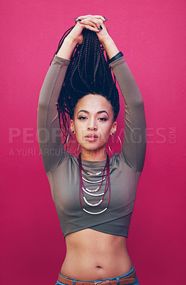 Buy stock photo Shot of an attractive young woman with braids posing against a pink background