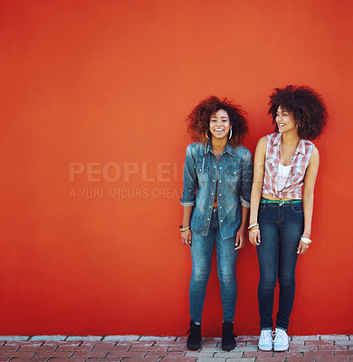 Buy stock photo Shot of two young friends posing in front of a red wall