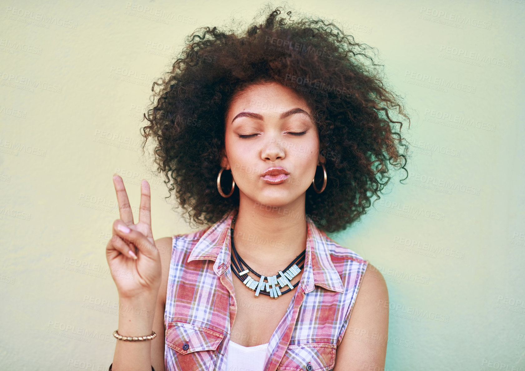 Buy stock photo Shot of an attractive young woman showing the peace sign