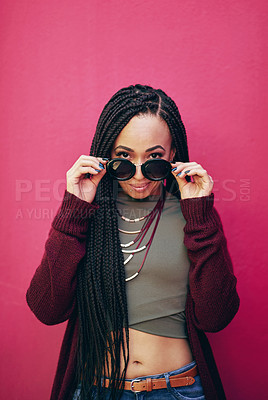 Buy stock photo Portrait of a young woman with braids posing against a pink background