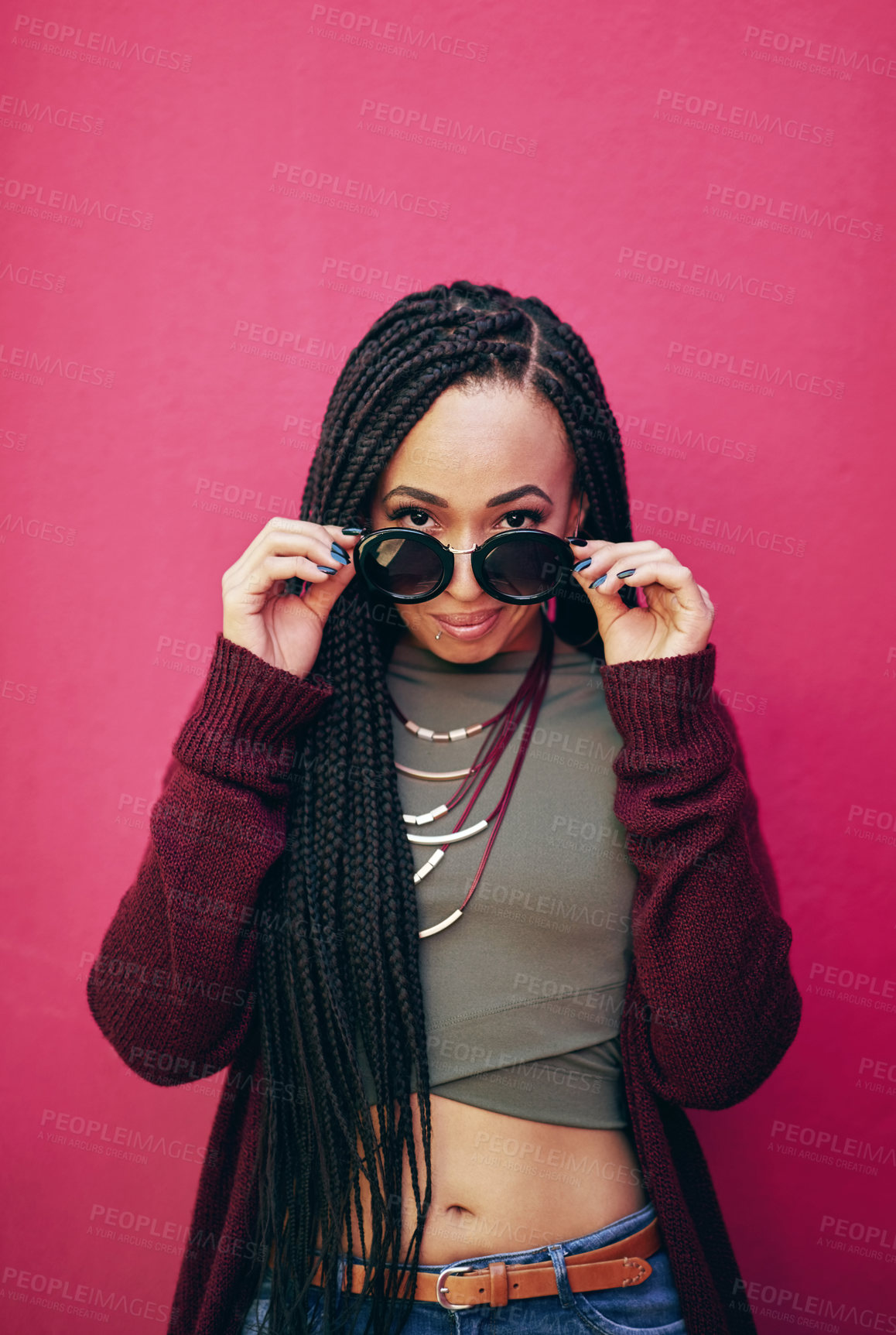 Buy stock photo Portrait of a young woman with braids posing against a pink background