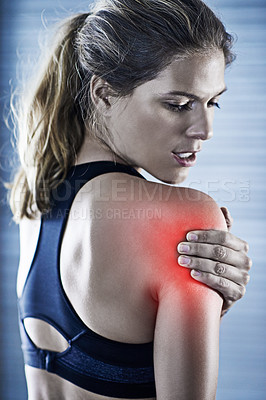 Buy stock photo Shot of a young woman holding her injured shoulder that's highlighted in red