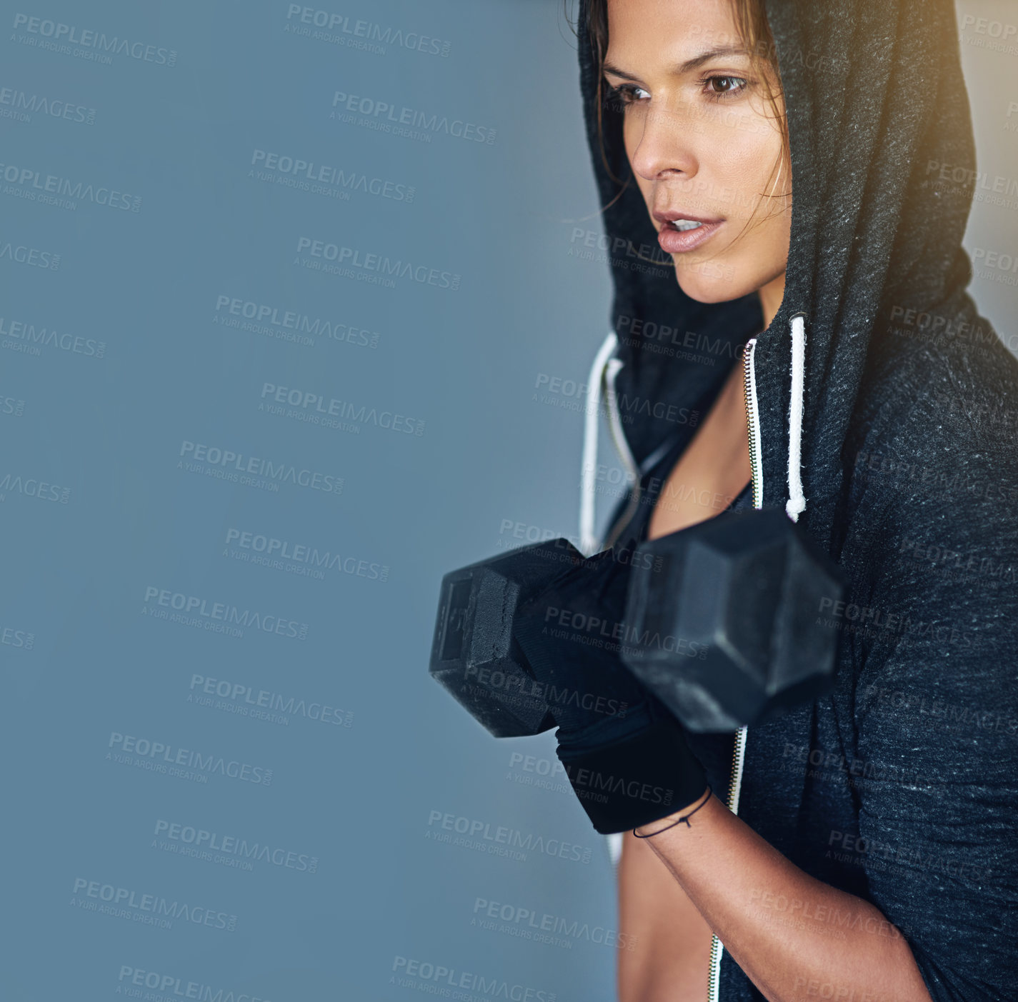 Buy stock photo Shot of a fit young woman working out with weights