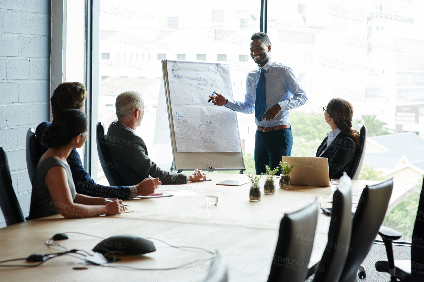 Buy stock photo Young black man doing leadership presentation on innovation at business shareholder meeting in office. Diverse work colleague group talking about company mission and vision development strategy.