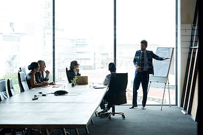 Buy stock photo Executive having a presentation in a boardroom at a modern office. Businesspeople listening to a serious business leader presenting a vision, thinking and mission for a project at the workplace.