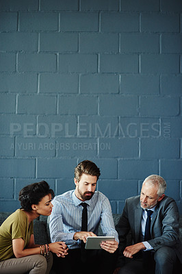 Buy stock photo Shot of a group of coworkers working together with a digital tablet