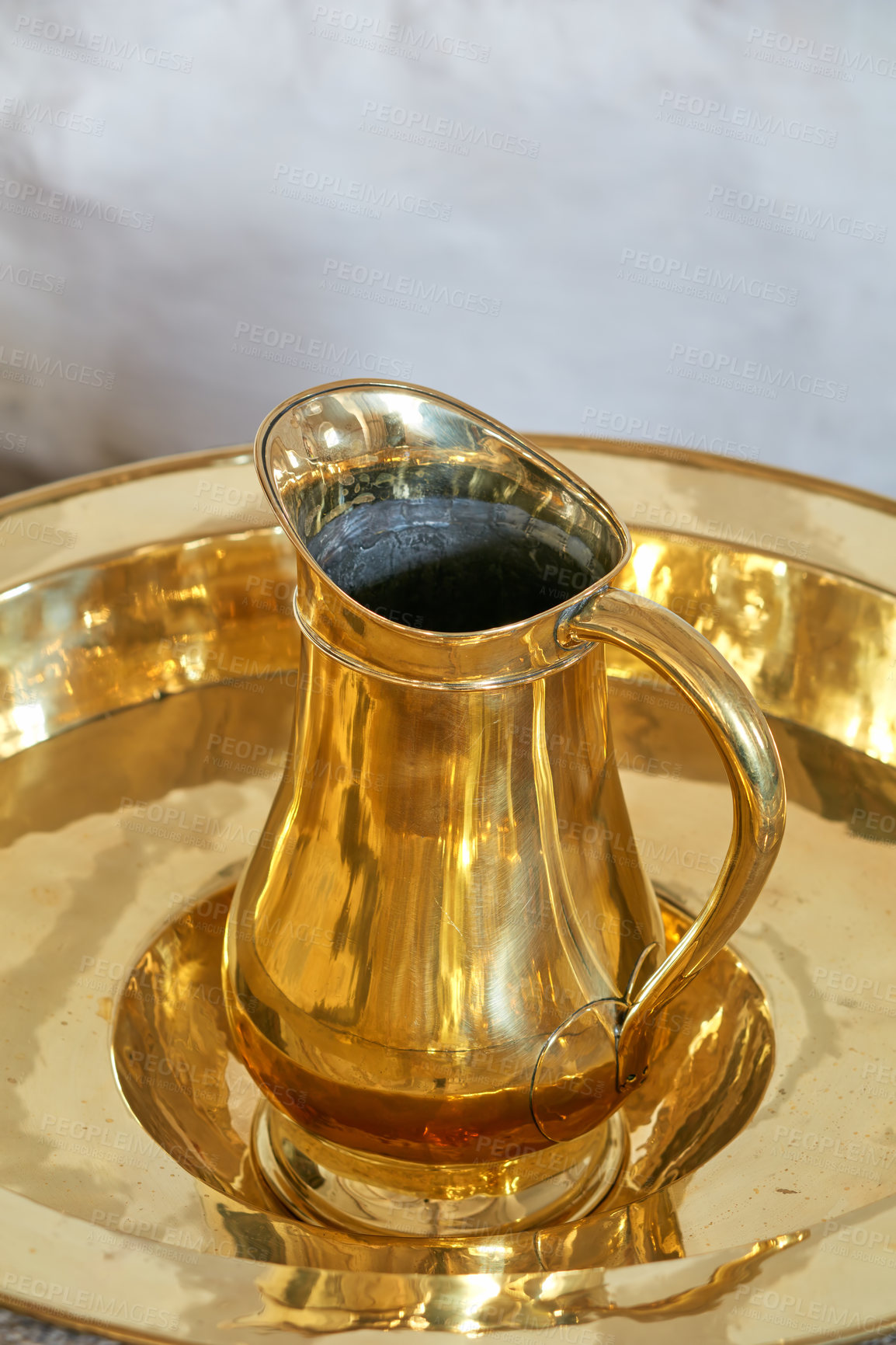 Buy stock photo Closeup of a gold baptism jug. Above of a water pouring furniture used as a sacred tool for christening ceremonies at church. A baptismal font, typical of the Danish National Church, Denmark