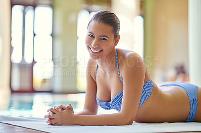 Buy stock photo Woman, portrait and happy poolside at spa for holiday, vacation and luxury wellness at resort with self care. Person, tourist and resting in bikini on towel for travel, smile and summer getaway