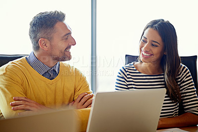 Buy stock photo Shot of coworkers working together on a laptop in an office