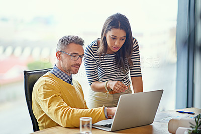 Buy stock photo Shot of coworkers working together on a laptop in an office