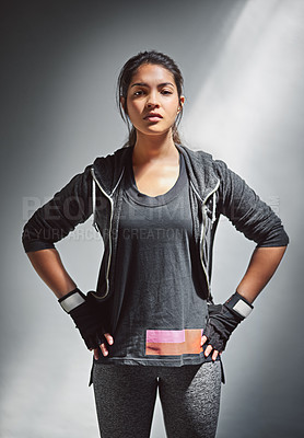 Buy stock photo Portrait of a fit young woman in sports clothing posing against a gray background