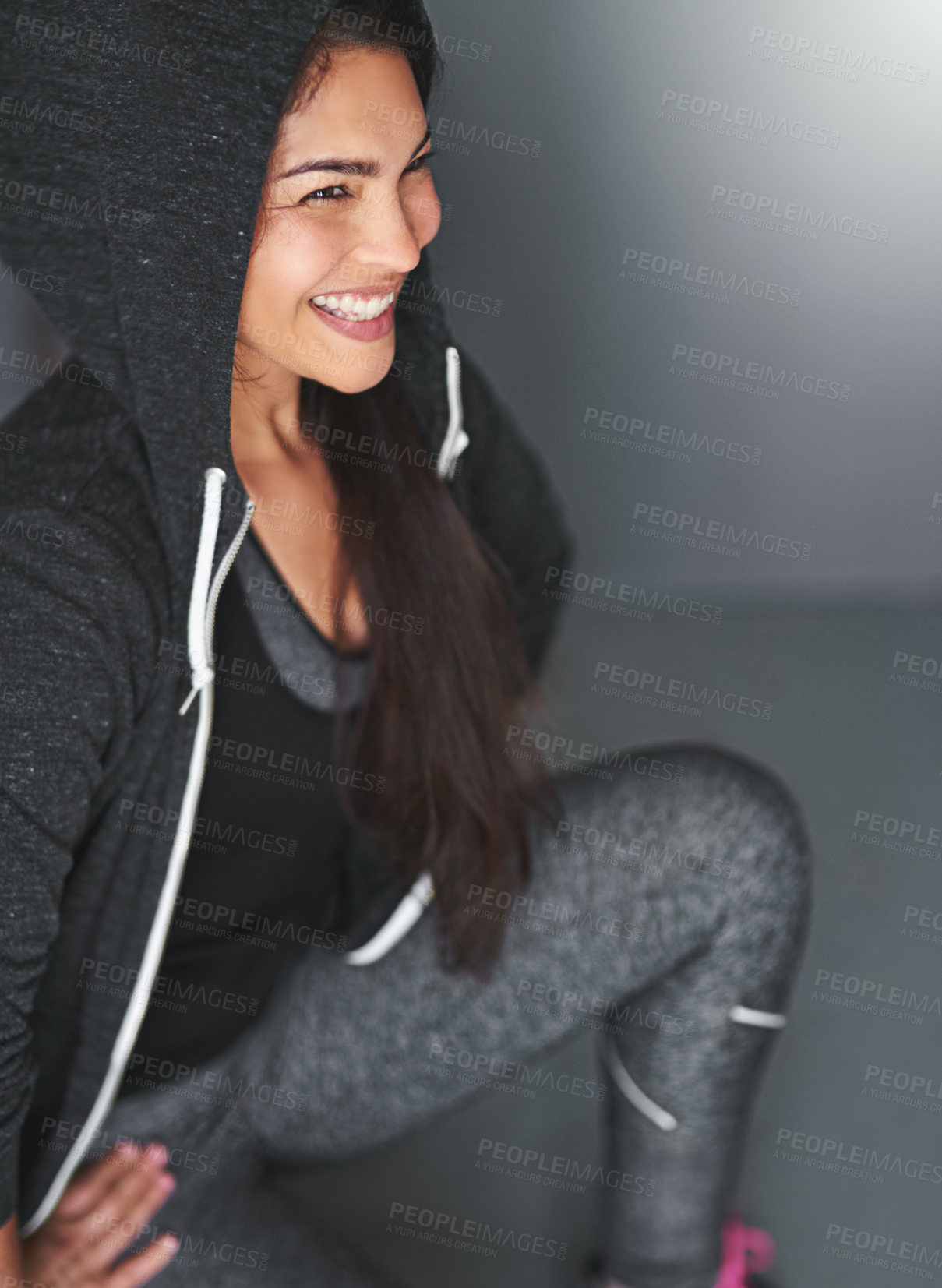 Buy stock photo Smile, squat and woman in gym for fitness, training and body wellness goals with hoodie in studio. Happy, health and girl with exercise for growth, development and sportswear on grey background