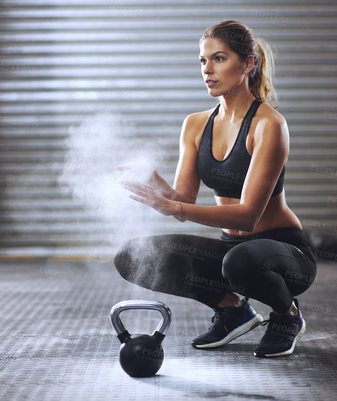 Buy stock photo Shot of a young woman coating her hands with sports chalk before a kettle bell workout