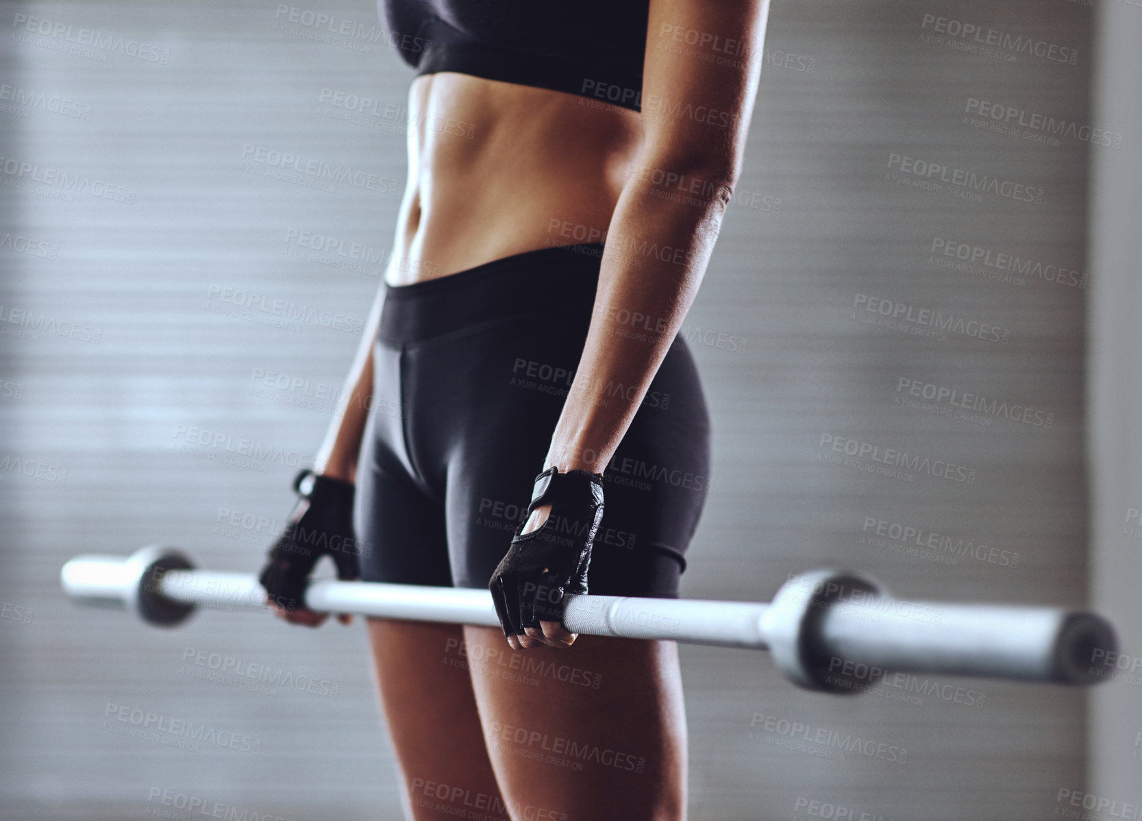 Buy stock photo Cropped shot of a woman training with weights at the gym
