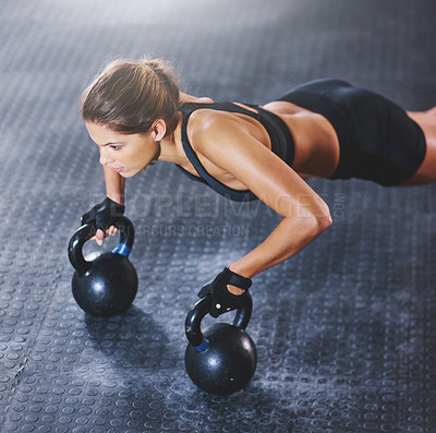 Buy stock photo Shot of a young woman working out with kettlebells