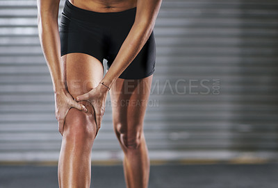 Buy stock photo Shot of a sportswoman with a knee injury