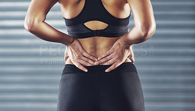 Buy stock photo Shot of a sportswoman with a lower back injury