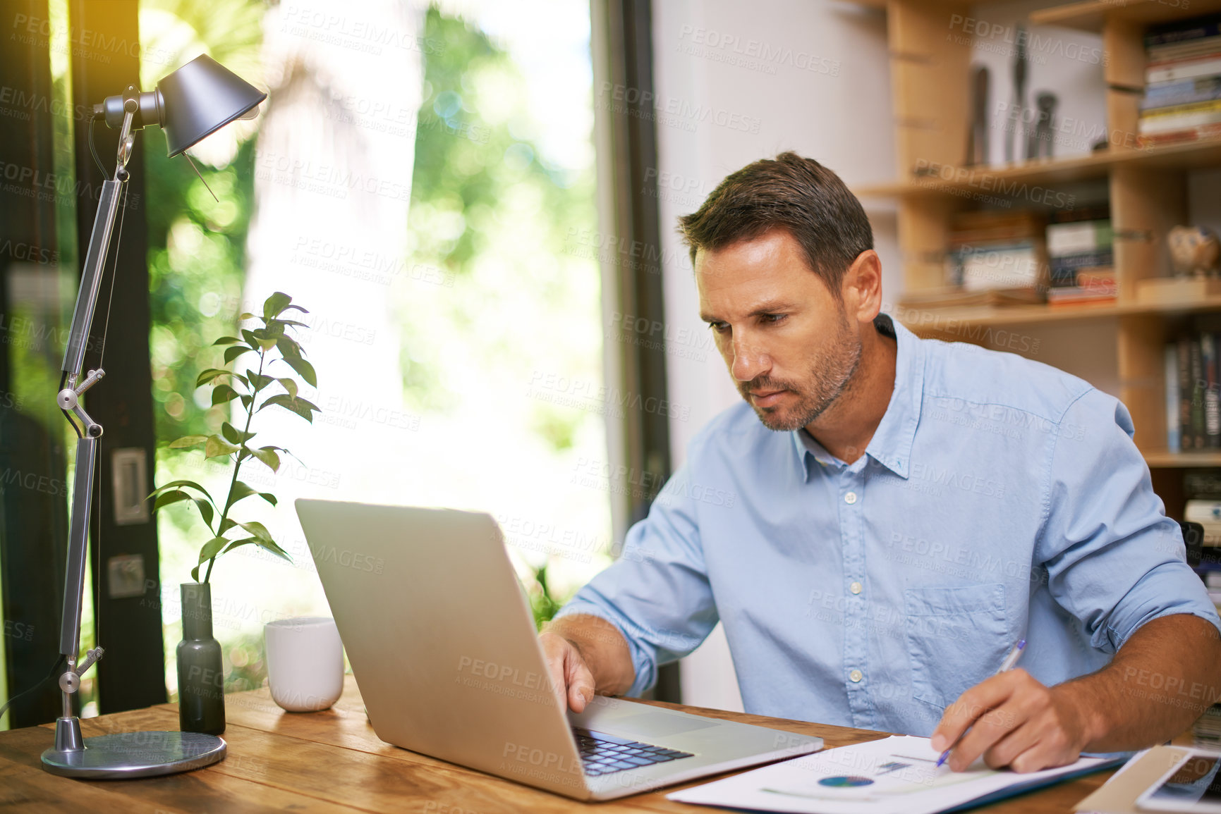 Buy stock photo Shot of a young man working from home