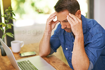 Buy stock photo Shot of a man suffering from a headache while working from home