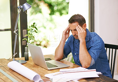 Buy stock photo Shot of a man suffering from a headache while working from home