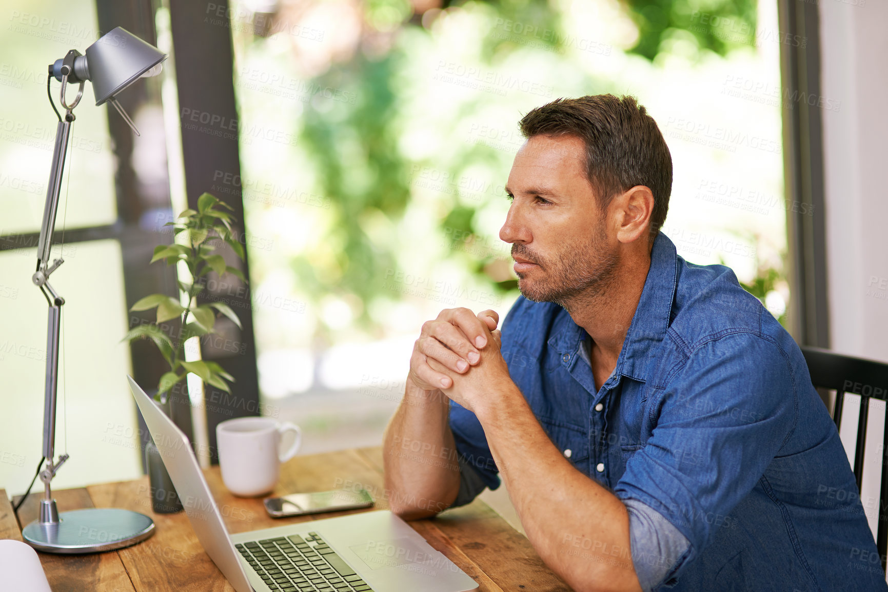 Buy stock photo Shot of a man looking thoughtful while working from home