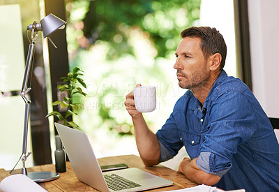 Buy stock photo Shot of a man drinking coffee while working from home